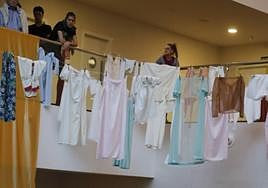 Imagen de unos jóvenes tendiendo la ropa en un espacio interior.
