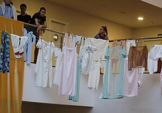 Imagen de unos jóvenes tendiendo la ropa en un espacio interior.