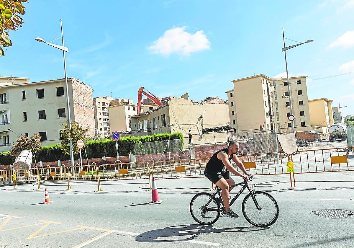 Un ciclista pasa por la calle Manuel Wsell de Guimbarda, frente a las obras de derribo del cuartel de la Guardia Civil.