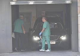 Un coche fúnebre traslada uno de los cuerpos desde el Instituto de Medicina Legal.