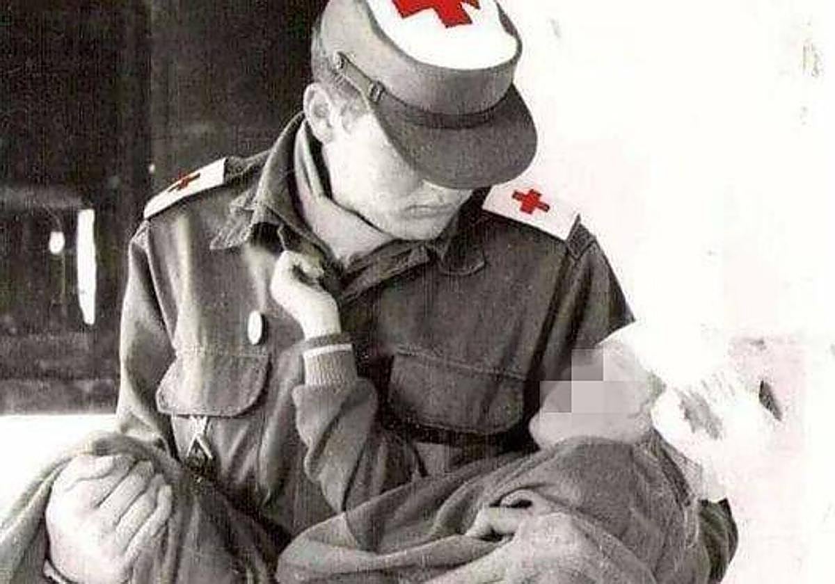 Un voluntario de Cruz Roja atiende a un niño herido en un accidente.