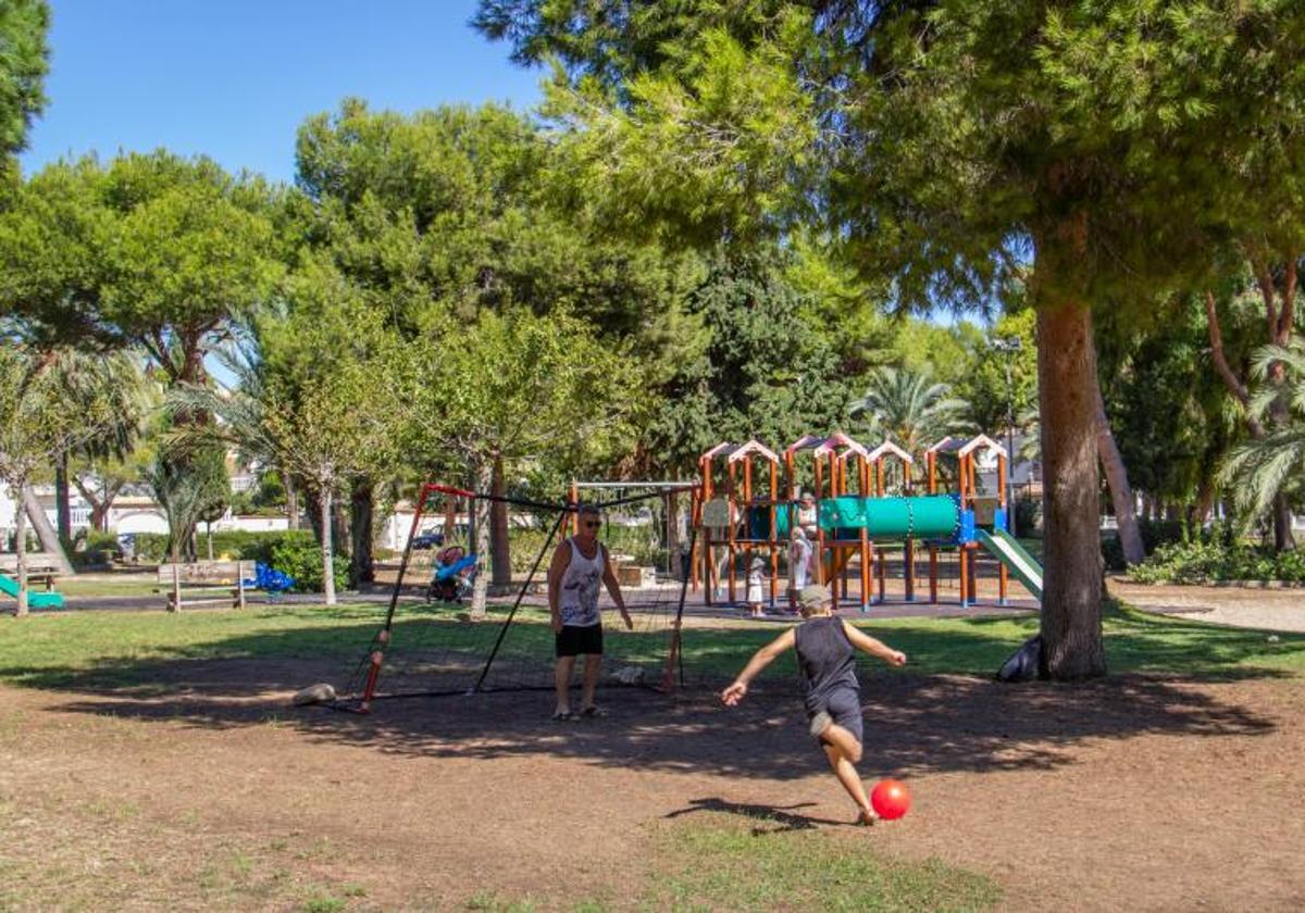 Un padre y un hijo juegan al fútbol en un parque de La Zenia, en Orihuela Costa.