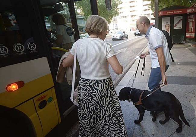 Miguel Ángel se dispone a entrar con su perra 'Molly' en un autobús de Murcia.