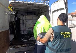 Un agente de la Benemérita arresta a uno de los sospechosos tras inspeccionar la furgoneta en la que transportaron el combustible.