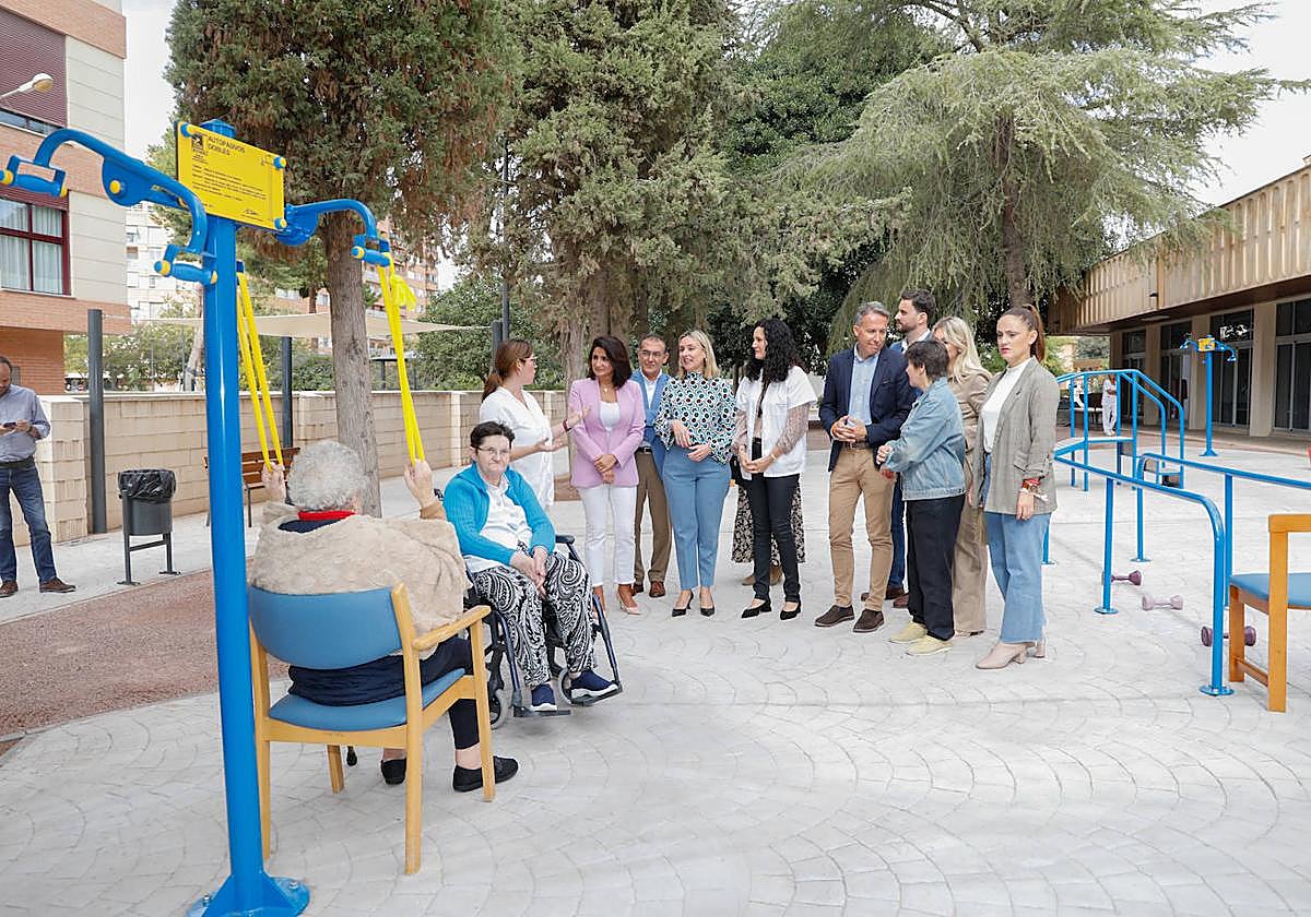 La consejera, concejales y personal de la residencia observan a los residentes hacer ejercicio en el jardín biosaludable.