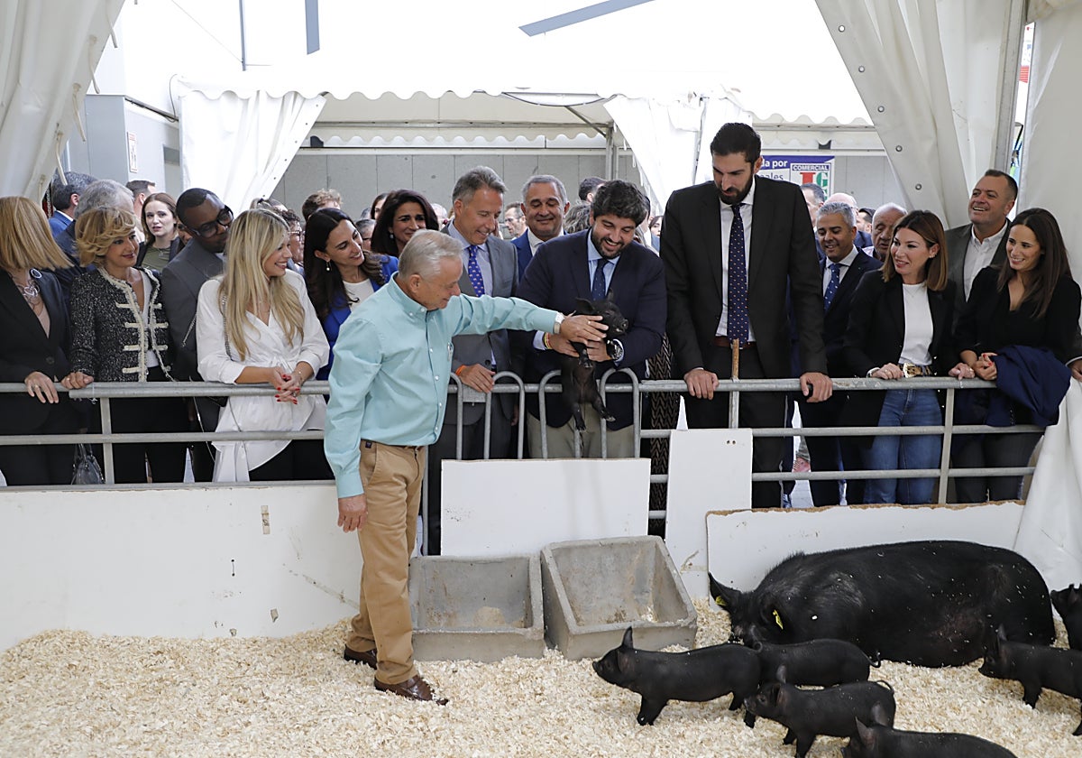 El presidente de la Región sostiene un lechón de chato murciano del ganadero José Reverte, en la inauguración de Sepor.