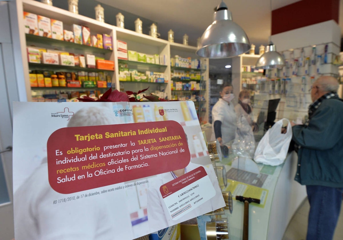 Cartel en una farmacia de Murcia que recuerda que la tarjeta sanitaria es imprescindible para la retirada de fármacos.