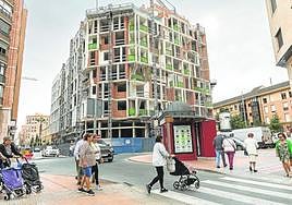 Vecinos cruzando un paso de peatones y de fondo el inmueble que está terminando de construir el arquitecto Bernardino García, frente al mercado de Santa Florentina.