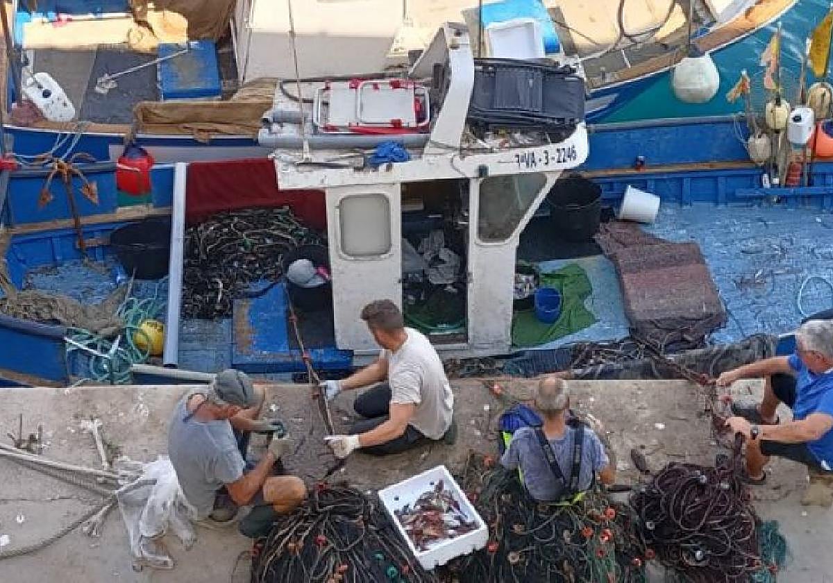 Pescadores arreglando los artes de pesca.