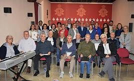 Parte de los componentes del coro de El Salvador posan junto a parte de la Junta Representativa de la Cofradía de la Vera Cruz en el Salón de Actos de la Casa de la Cruz.