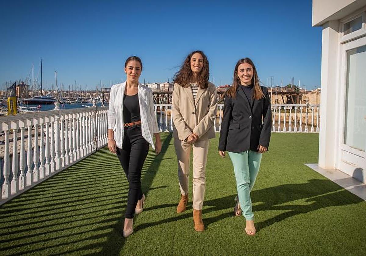 Beatriz, Mireya y Paula caminan por la terraza de la Oficina de Turismo, con vistas a las Eras de la Sal y la bahía portuaria.