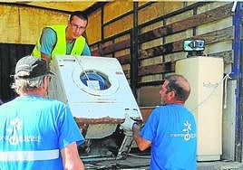 Unos trabajadores recogen enseres.