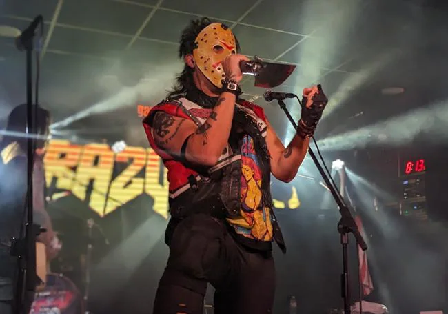 Danny Rexon, singer of Crazy Lixx, dressed in a Jason Vorhees mask and a machete-microphone.