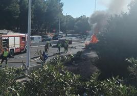 Los Bomberos apagan el incendio desatada en uno de los coches tras el accidente.