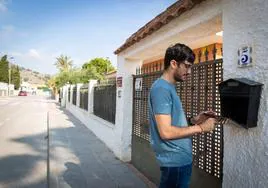 Un vecino rebusca cartas en el buzón de su casa en la urbanización Montepinar.