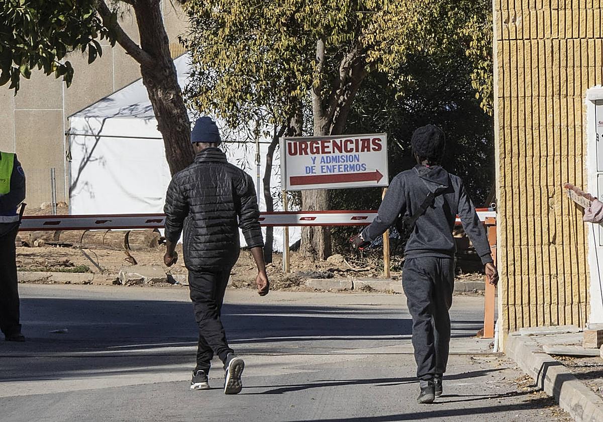 Dos inmigrantes entra al campamento temporal del Hospital Naval.