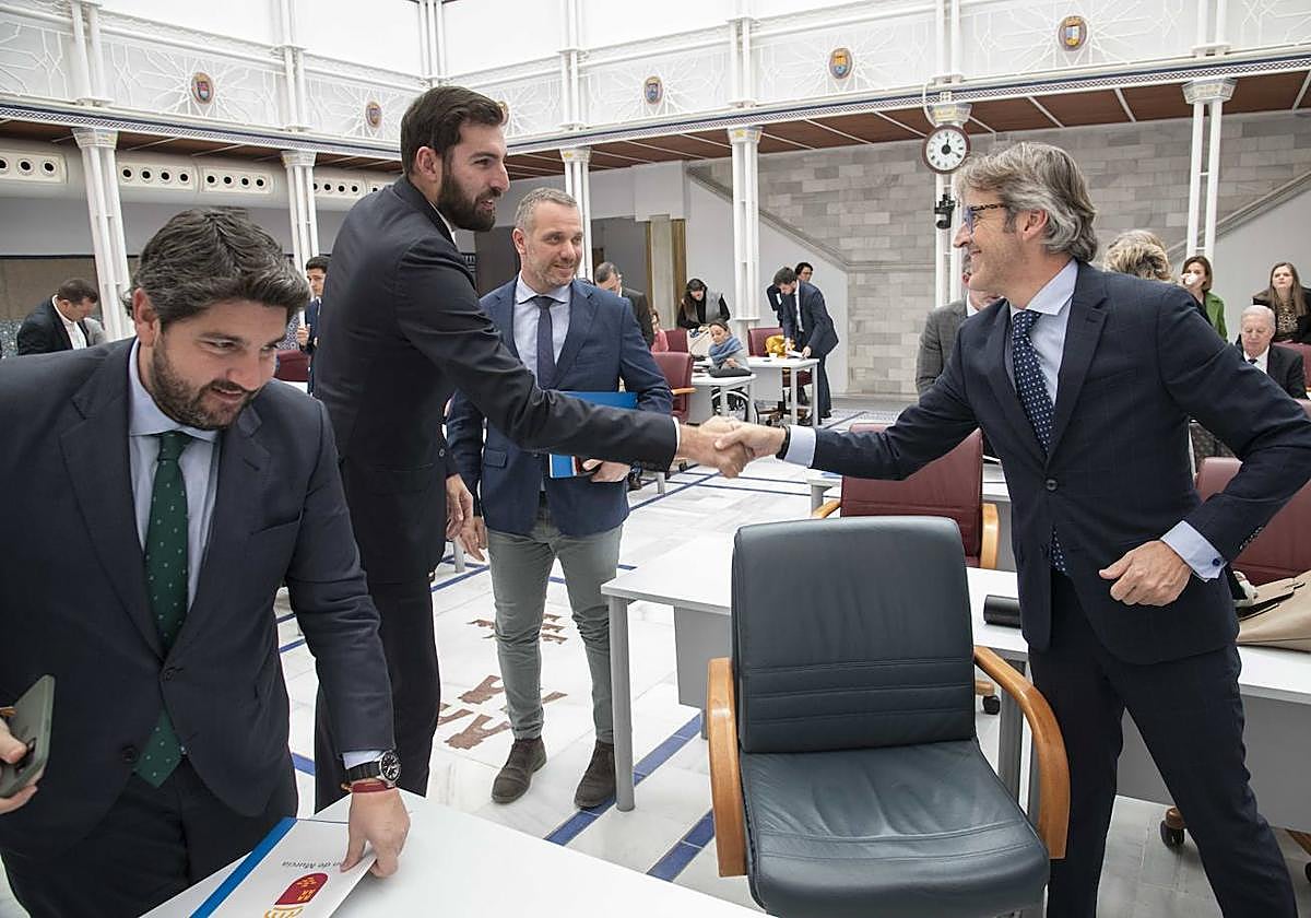 José Ángel Antelo y Luis Alberto Marín se dan la mano este martes, en la Asamblea Regional, en presencia de Fernando López Miras y Joaquín Segado.