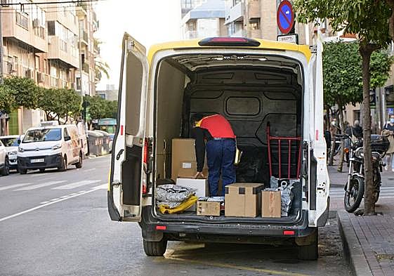 Un repartidor selecciona paquetes para su entrega en una zona de carga y descarga del centro de Murcia, en una imagen de archivo.