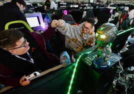 Dos asistentes a la Lan Party celebran una victoria en un videojuego.