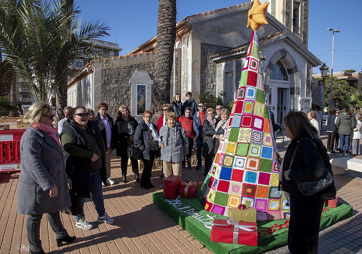 Vecinos de Los Urrutiascontemplan el árbol navideño de ganchillo, este domingo.