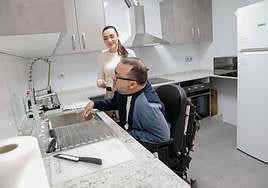 José Luis Llamas en la cocina adaptada del piso junto a la trabajadora social Ana Belén Romera.