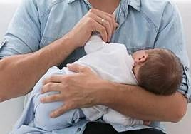 Un padre con un bebé en brazos.