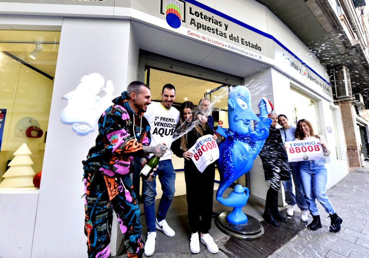 Varias personas celebran en la administración Genio de la Lotería de Murcia haber repartido El Gordo de la Lotería de Navidad, este viernes.