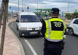 Un agente frente al vehículo que conducía el hombre sancionado.