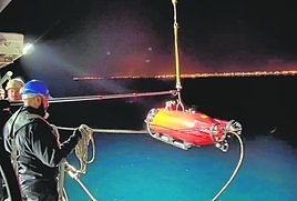 Marinos del 'Tambre' despliegan el robot Pluto frente a un puerto para tareas de reconocimiento subacuático.