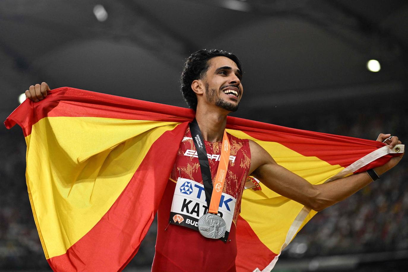 El atleta muleño Mo Katir consigue una plata histórica en el Mundial de Budapest tras llevar al límite al noruego Ingebrigtsen. Sólo 14 centésimas separaron del oro al murciano, que hizo una final de los 5.000 metros sensacional y se desquitó de su fracaso en la semifinal del 1.500. «Hoy he conseguido la plata y ojalá el año que viene me toque el oro. Es año olímpico y eso sí que sería cerrar el círculo», explicó con una sonrisa en la cara.