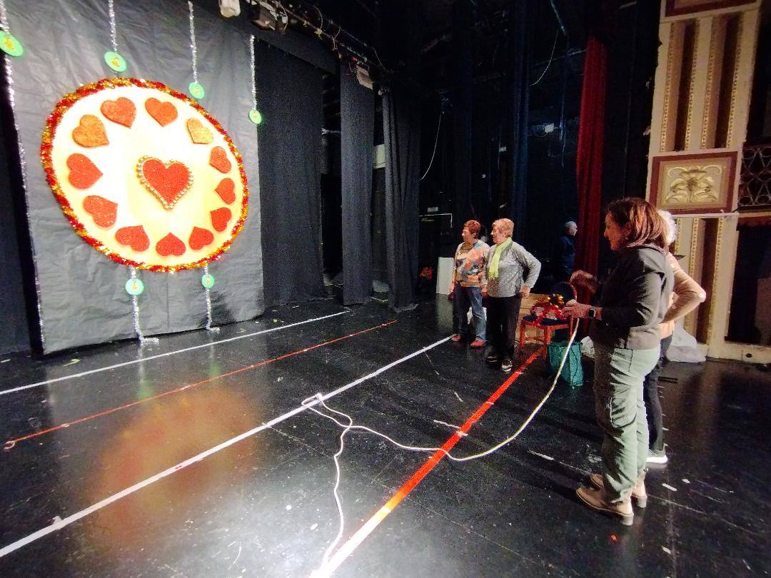 Varias personas de la asociación Unidad y Fraternidad dan los últimos retoques a la decoración del teatro Thuillier