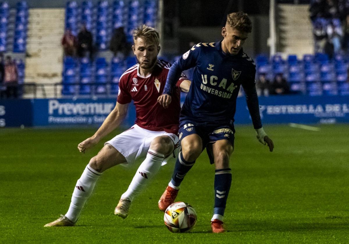 Josema Raigal protege el balón ante Sergio Santos.