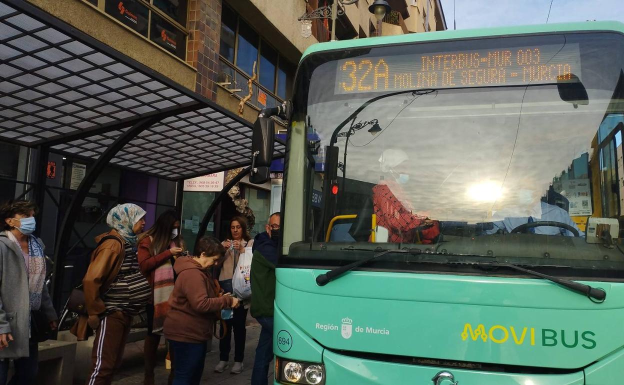 Varias personas cogen este lunes el autobús en Molina para ir a Murcia. 