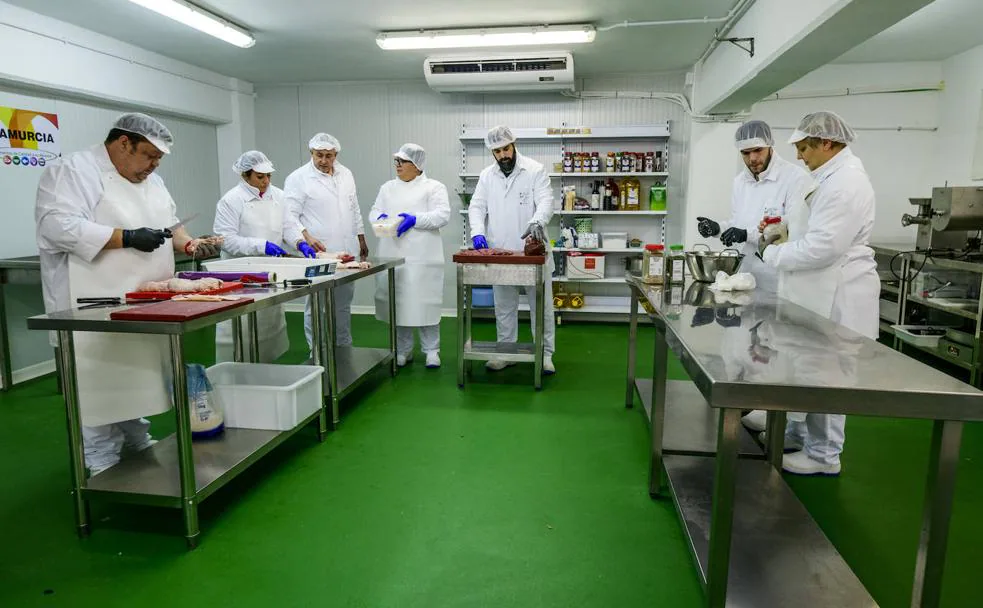 Alumnos del primer curso de carnicería en el taller de formación, con el profesor (3i) Ramón Rodríguez.