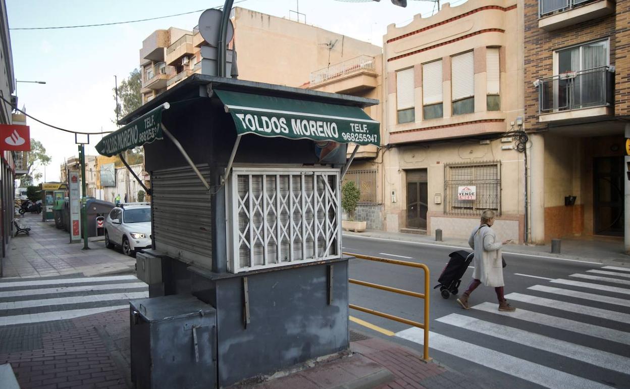 Una vecina cruza la calle Mayor, donde se localiza el quiosco, cerrado desde hace años.