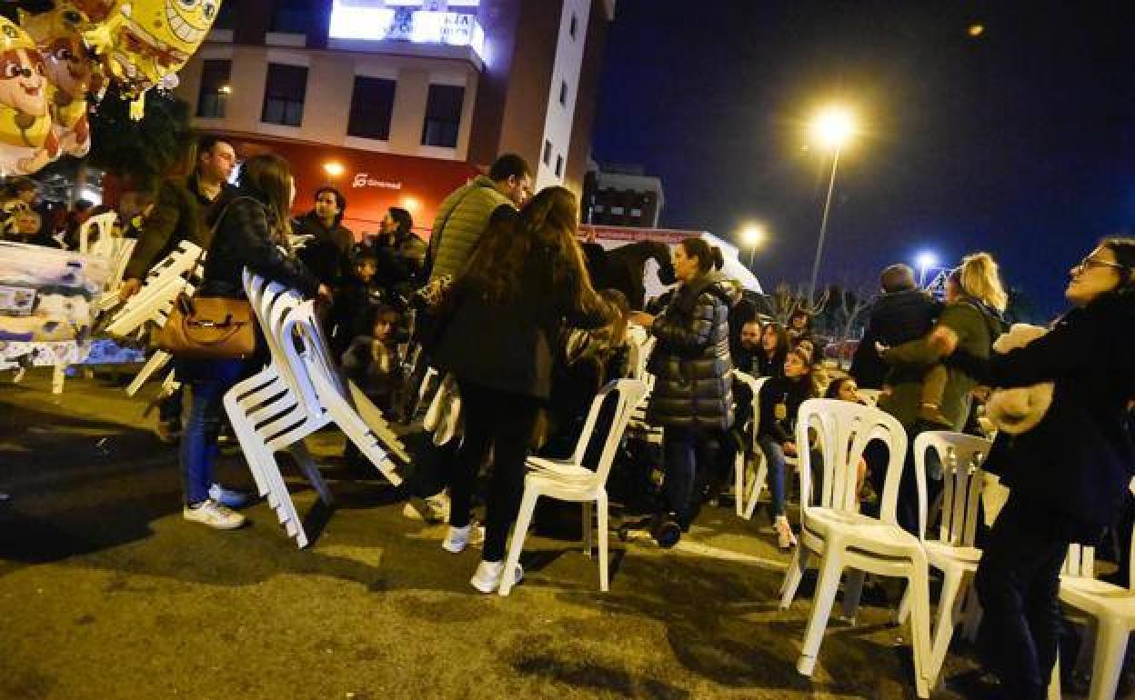 Asistentes a la Cabalgata de Reyes de Murcia, recolocando las sillas. 