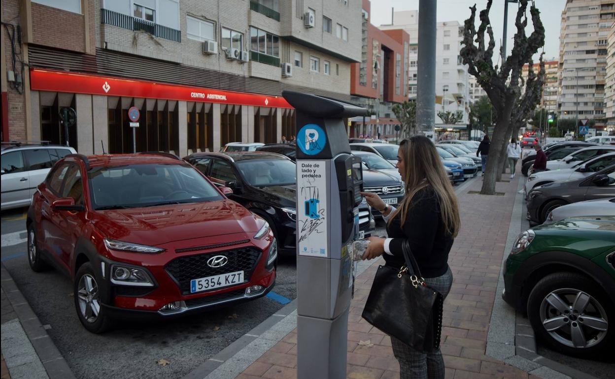 Una joven abona la zona azul frente al Palacio de San Esteban.