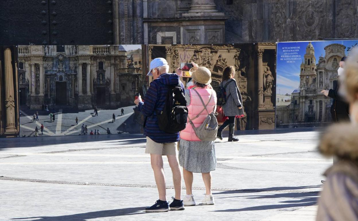 Dos turistas sacan fotos en la plaza Cardenal Belluga de Murcia en una imagen de archivo. 