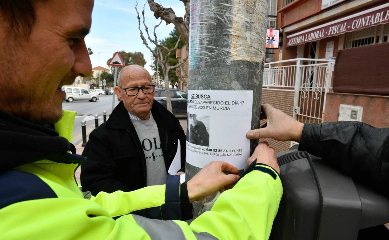 Familiares de Ramón Robledo pegan carteles con su foto en El Palmar. 