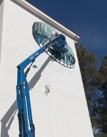 Imagen secundaria 2 - Detalles de los murales en la fachada de la Sala de Plegados de la Escuela Militar de Paracaidismo Méndez Parada de Alcantarilla. 