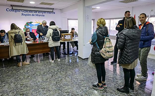 Varios colegiados se acercan a las mesas electorales para depositar su voto, este viernes. 