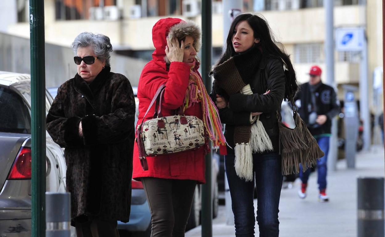 Imagen de archivo de tres mujeres con abrigos en un frío día de invierno. 