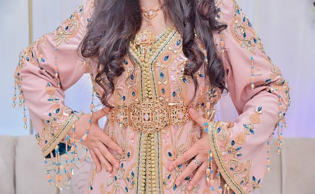 Mangas y cintura del caftán rosa con bordados de hilo de oro y piedras azules, además de una especie de pulseras colgando de las mangas y el cinturón de acero, llamado 'mdama'.