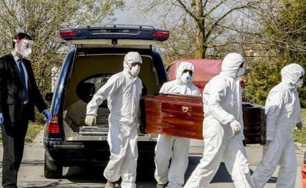 Funeral home workers carry the body of a deceased by covid.
