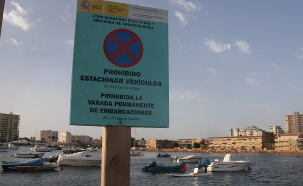 Boats anchored on the beach of Puerto Bello, in La Manga, in front of a prohibition sign.  The photo is archival. 