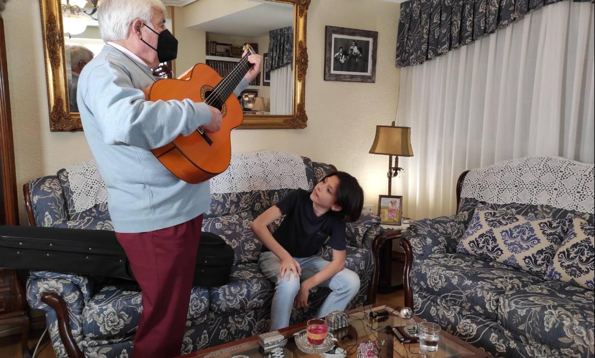 El guitarrista cartagenero Antonio Piñana, con su nieto Rafa, que sigue atentamente las lecciones de su abuelo