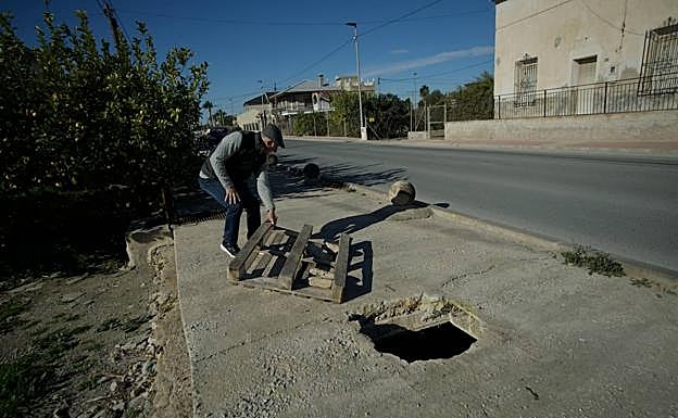 Francisco García retira uno de los palés de madera con los que se señalizan los agujeros en el cimbrado que ha dejado el robo de las tapas de arqueta.