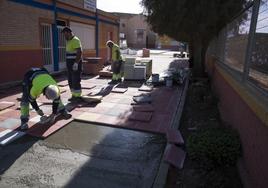 Tres albañiles ponen losas en el patio del colegio San Isidoro de El Algar, ayer.