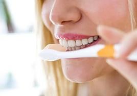 Una chica cepillándose los dientes.