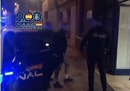 Dos agentes de la policía arrestan a uno de los culpables.